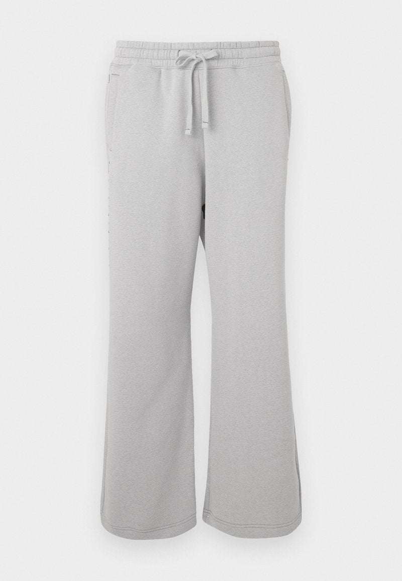 Hellgraue Jogginghosen aus weichem Material, mit weitem Bein, elastischem Bund mit Kordelzug und seitlichen Taschen.