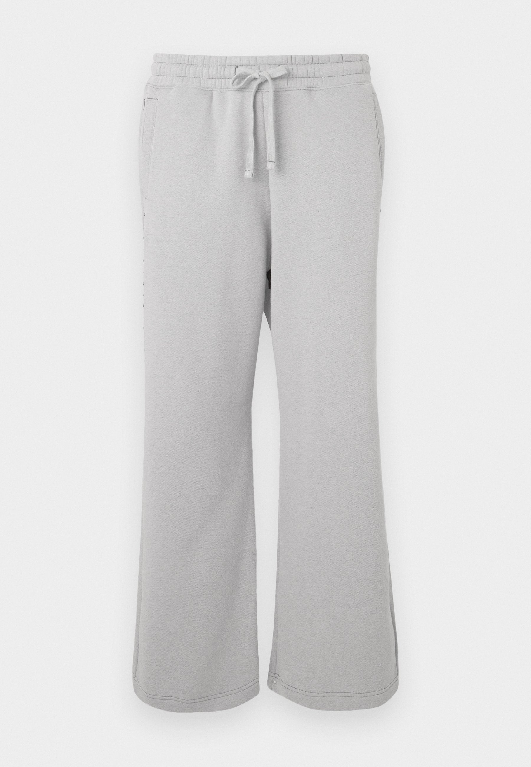 Hellgraue Jogginghosen aus weichem Material, mit weitem Bein, elastischem Bund mit Kordelzug und seitlichen Taschen.