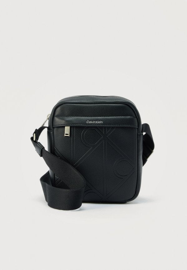 Calvin Klein EMBLEM AOP EMBOSS REPORTER - Cross body bag - black