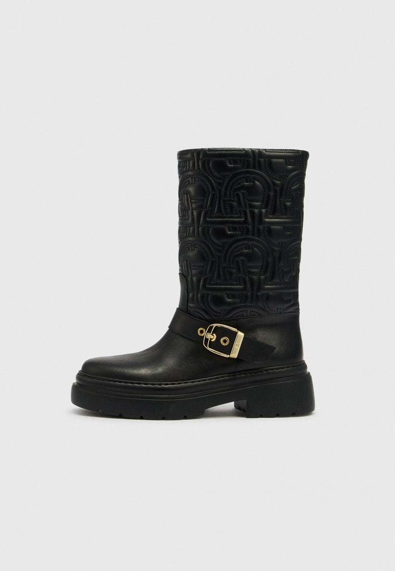 Schwarzer kniehoher Lederstiefel mit Muster und klobiger Sohle, mit goldener Schnalle als Akzent und strukturiertem Obermaterial.