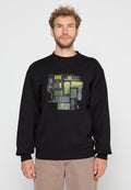 Mann trägt einen schwarzen Sweatshirt mit einer Grafik von verschiedenen Vintage- und modernen Mobiltelefonen in grünen und grauen Farbtönen.
