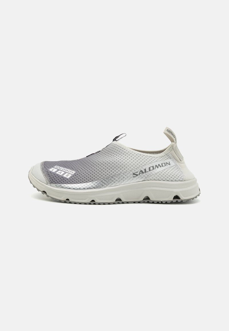 Leichte Slipper aus grauem und weißem Mesh-Obermaterial. Strukturierte Oberfläche, Gummi-Außensohle und dezente Branding-Details.