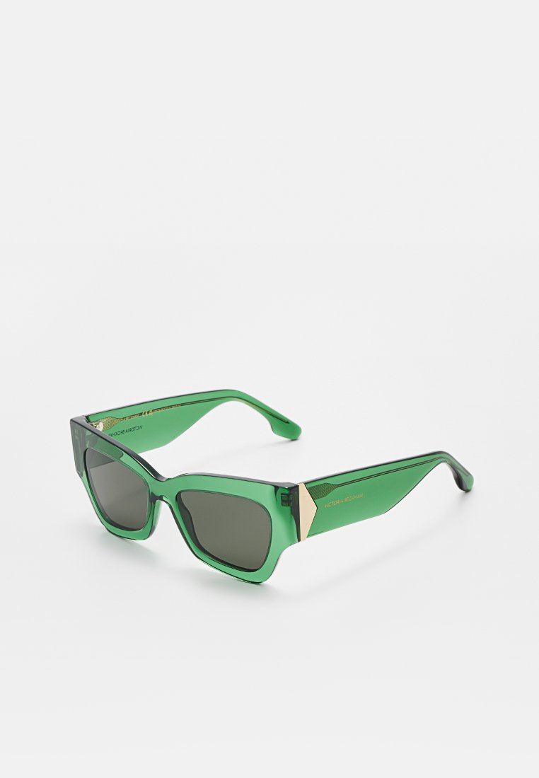 Grüne Sonnenbrille mit einem durchsichtigen Rahmen, eckigem Design, dunklen Gläsern und einem goldenen Akzentdetail an den Bügeln.