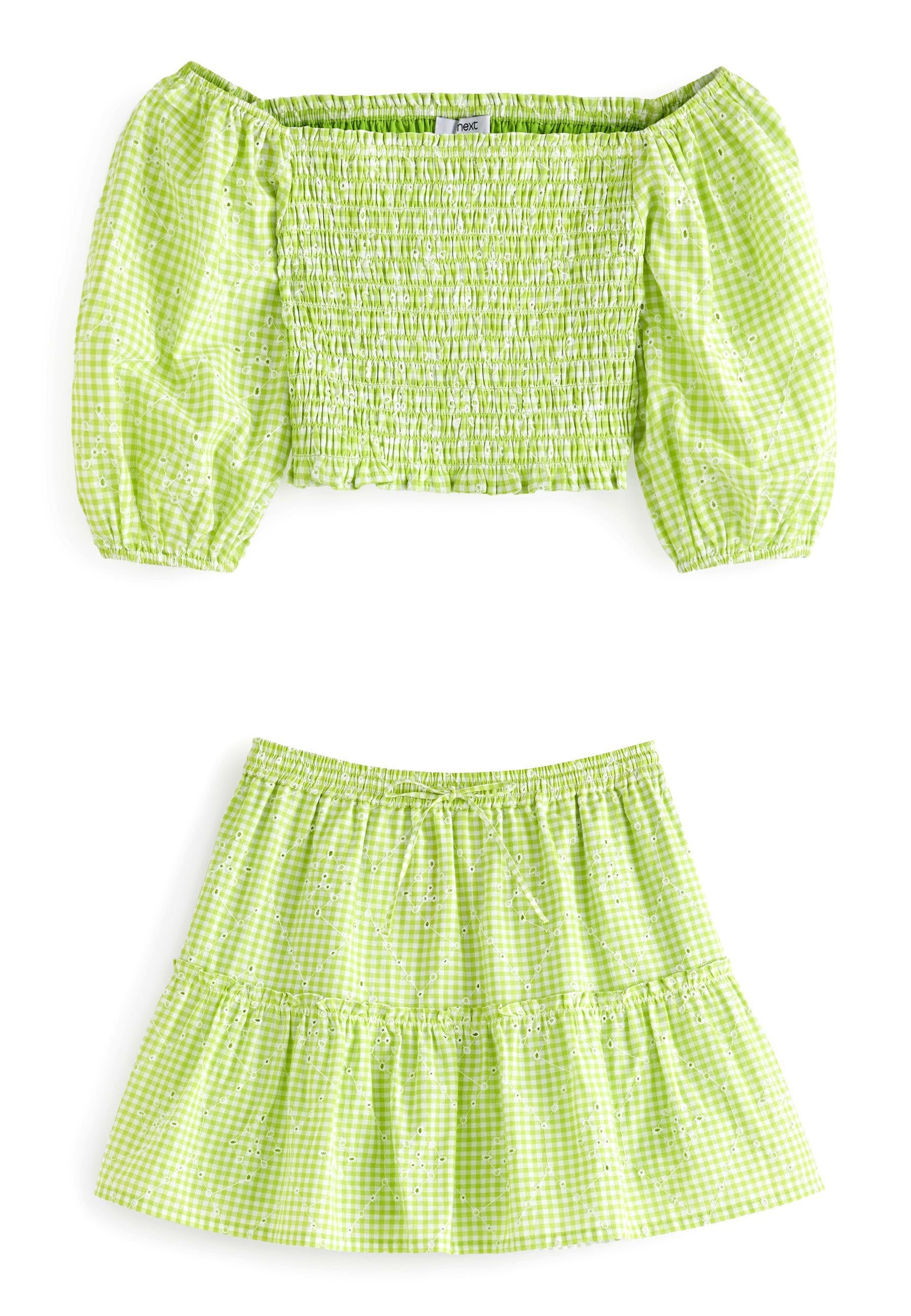 Grünes Gingham-Crop-Top mit Puffärmeln und gerafftem Brustbereich, kombiniert mit einem passenden, gestuften Rock mit elastischem Bund und Lochmuster-Details.