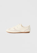 Sneakers in Cremefarben mit Obermaterial aus Wildleder und Stoff, abgerundete Zehenpartie und Gummisohle mit beigefarbenem Akzent. Schnürsenkelverschluss.