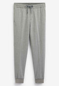 Graue Jogginghose aus weichem Stoff; elastischer Bund mit Kordelzug; schmal zulaufende Beine mit gerippten Bündchen; Seitentaschen.