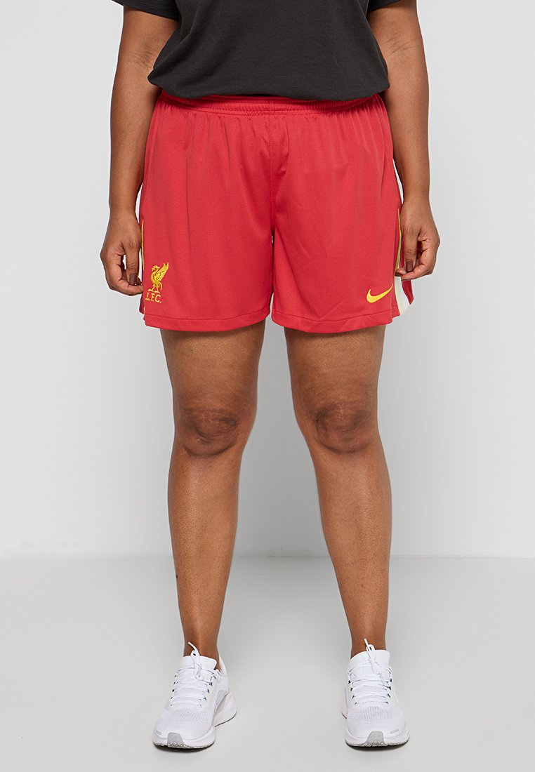 Rote Sportshorts aus atmungsaktivem Netzstoff, mit einem gelben Nike-Logo und dem Liverpool FC-Wappen auf der Vorderseite, elastischer Bund.