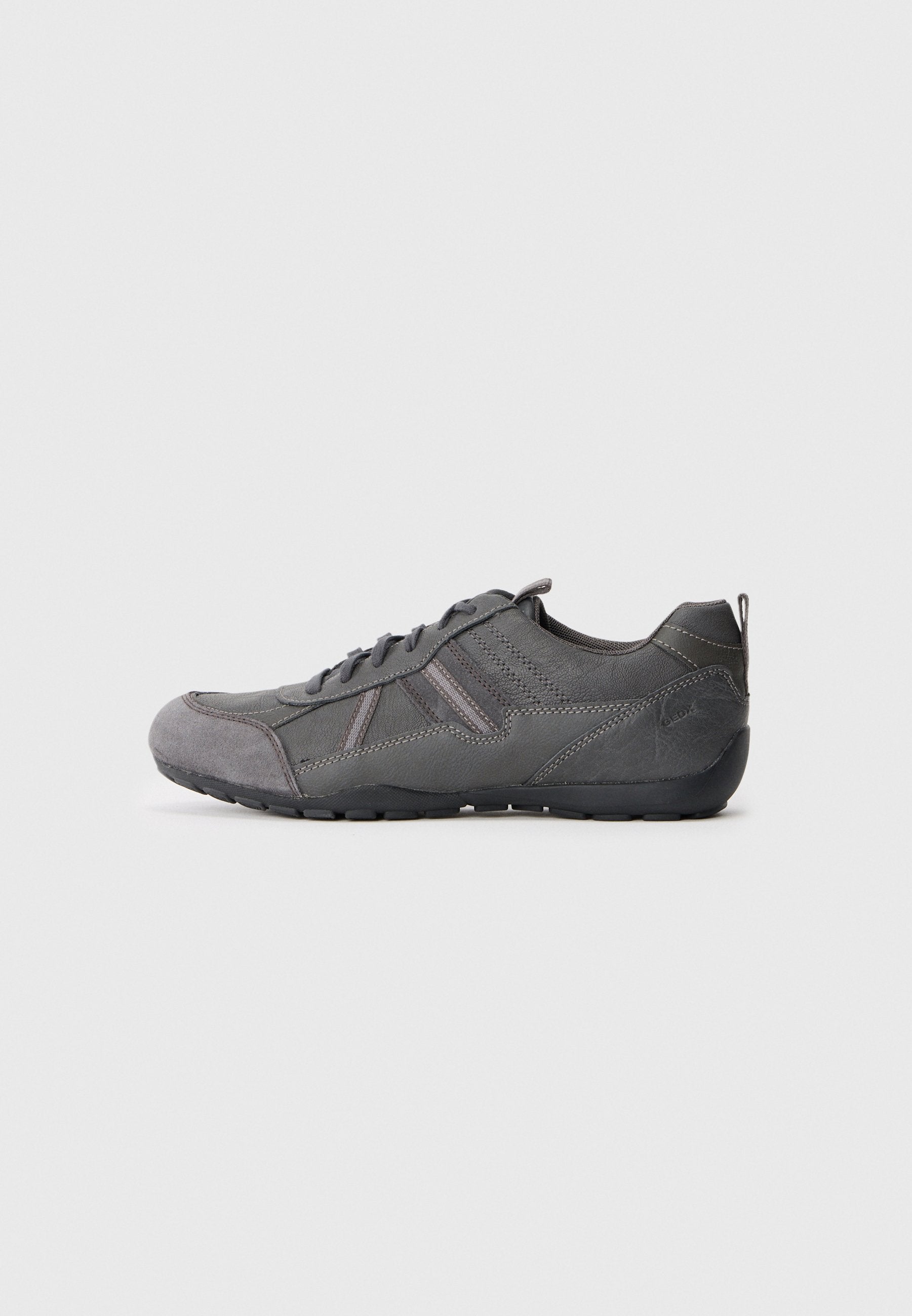 Grauer Sportschuh mit abgerundetem Zehenbereich, glattem Obermaterial aus Leder und Wildleder, verstärkten Nähten und Gummisohle mit strukturiertem Grip.