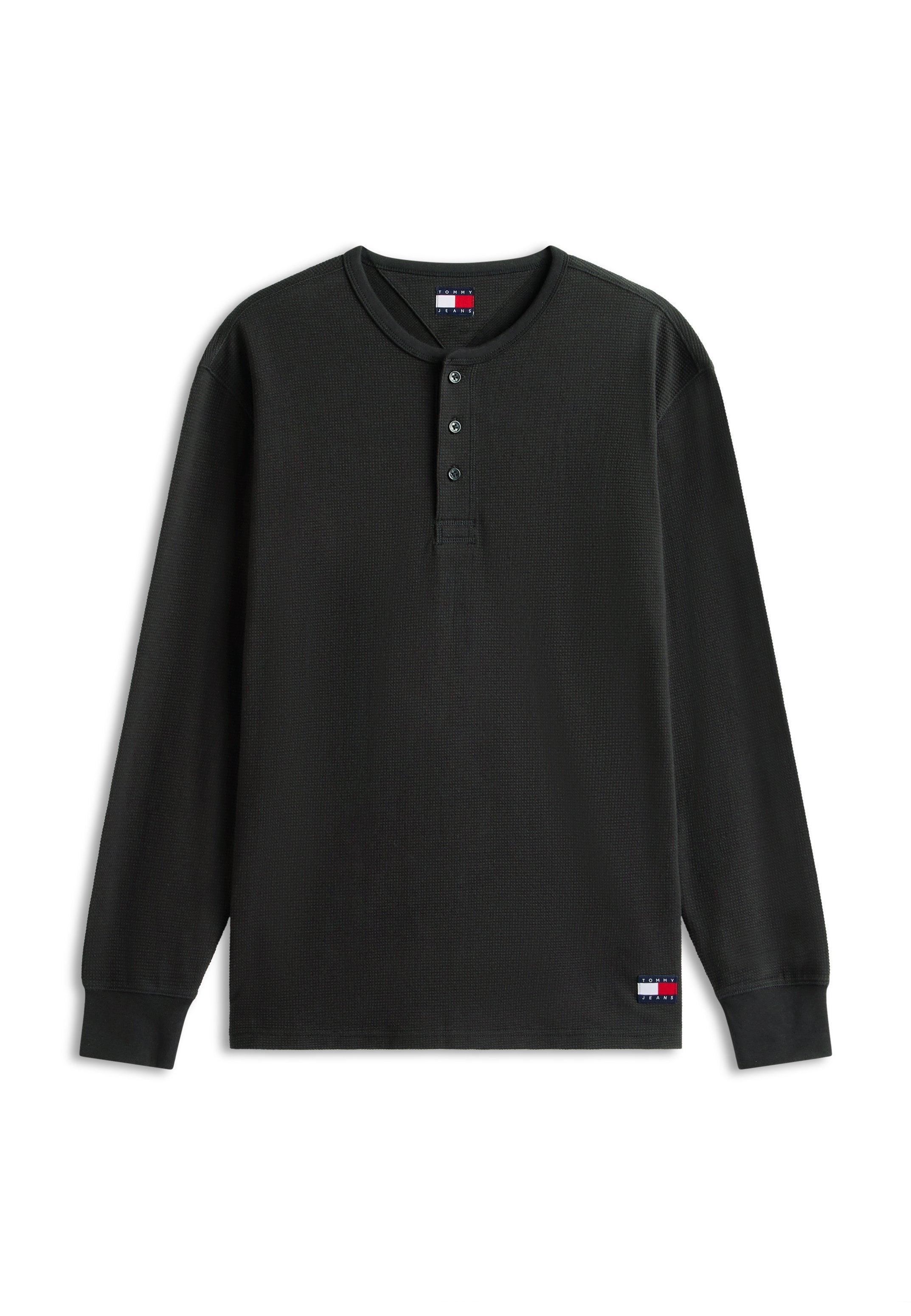 Schwarzes langärmliges Waffelstrickshirt mit drei Knöpfen am Kragen und kleinen Tommy Jeans Logo-Patches auf Brust und unterem Saum.