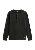 Schwarzes langärmliges Waffelstrickshirt mit drei Knöpfen am Kragen und kleinen Tommy Jeans Logo-Patches auf Brust und unterem Saum.