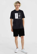 Schwarzes Baumwoll-T-Shirt mit grafischem Druck im Sternen-Motiv, kombiniert mit schwarzen Cordshorts und weißen Sneakers.