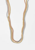 Metallene Halskette mit miteinander verwobenen Strängen in Silber, Gold und Roségold. Glatte Textur mit einem flexiblen, schlangenartigen Design.
