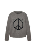 Grauer Strickpullover mit einem schwarzen geometrischen Friedenssymbol auf der Vorderseite und absichtlich eingearbeiteten Löchern im Stoff.