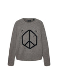 Grauer Strickpullover mit einem schwarzen geometrischen Friedenssymbol auf der Vorderseite und absichtlich eingearbeiteten Löchern im Stoff.
