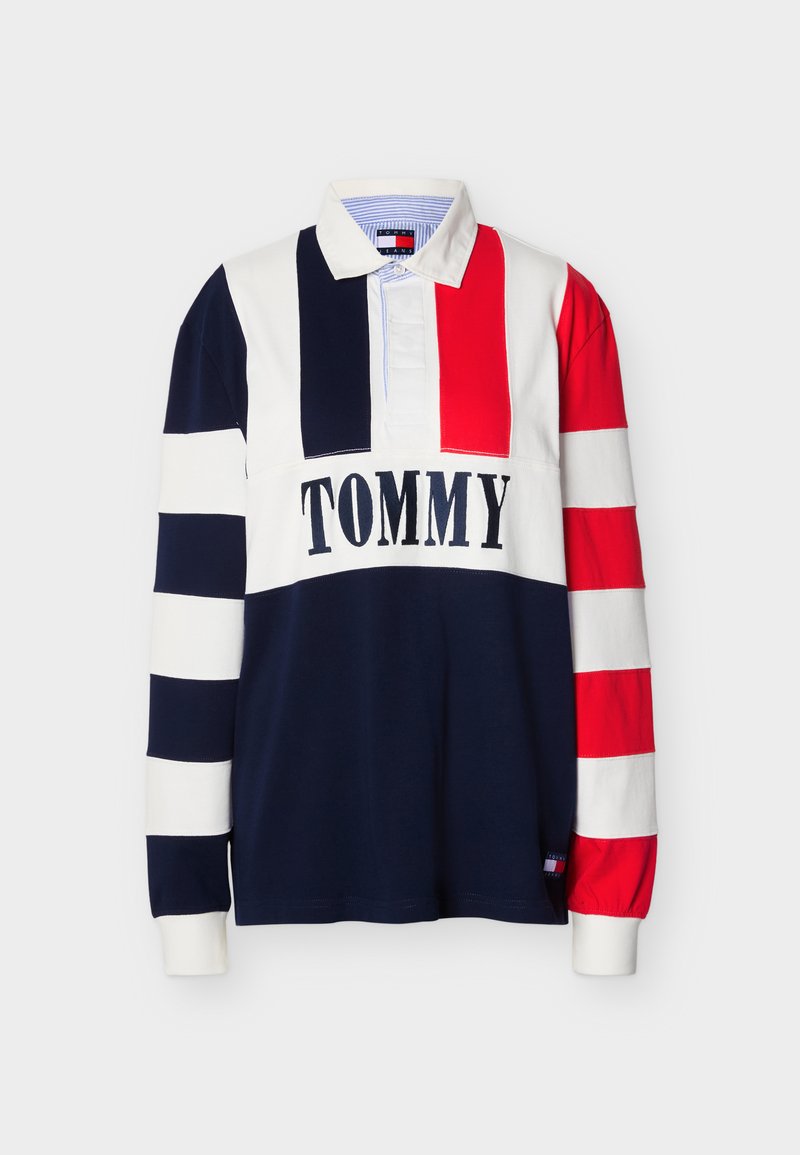 Langärmeliges Rugby-Shirt mit rot-weißen und marineblauen Streifen, weißem Kragen und dem Schriftzug "TOMMY" quer über der Brust.