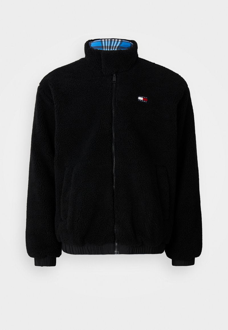 Schwarze Fleecejacke mit hohem Kragen, Frontreißverschluss, elastischen Bündchen und Saum; verfügt über ein blaues und kariertes Innenfutter. Kleines Logo-Detail auf der Brust.