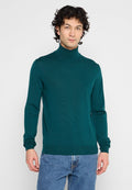 Dunkelblauer Rollkragenpullover mit gerippter Textur, tailliertem Schnitt und langen Ärmeln. Kombiniert mit hellblauen Jeans.