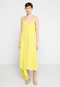 Gelbes ärmelloses Kleid mit tiefem V-Ausschnitt, asymmetrischem Saum und dekorativen Trägern mit metallischen Akzenten. Glattes, leichtes Material.