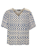 Kurzärmelige Bluse mit V-Ausschnitt, aus leichtem Stoff gefertigt. Sie hat einen cremefarbenen Hintergrund mit blauen Quadratmustern.
