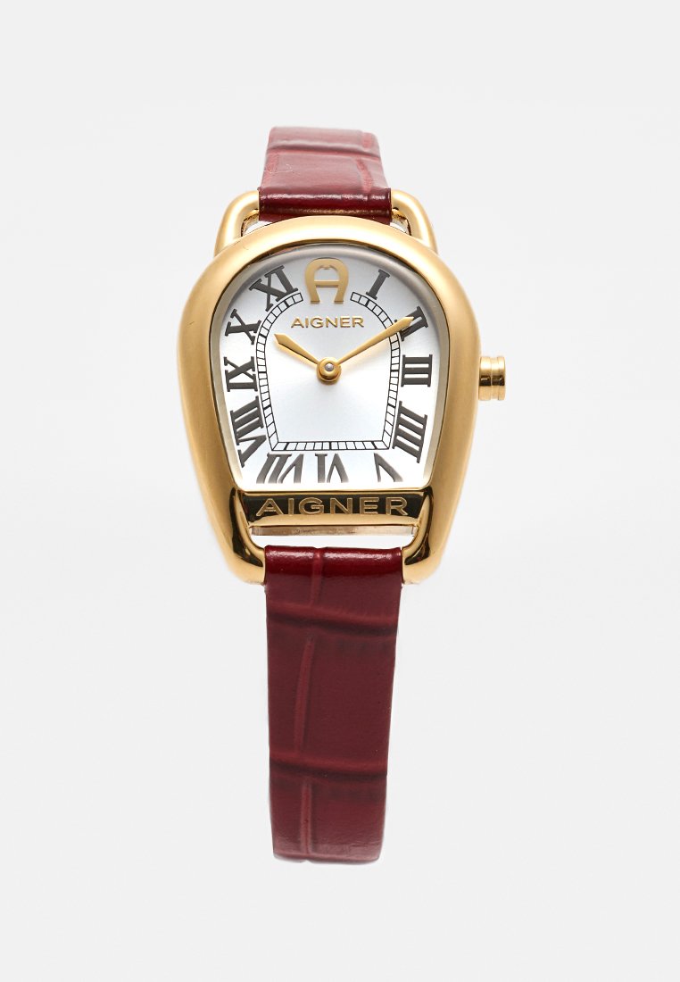 Goldene Aigner Uhr mit weißem Zifferblatt, schwarzen römischen Ziffern, goldenen Zeigern und einem strukturierten dunkelroten Lederarmband.