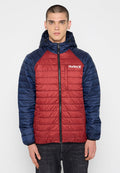 Rote und marineblaue isolierte Jacke mit einem gesteppte Muster, Frontreißverschluss, Kapuze und Logo auf der Brusttasche. Diese Jacke hat lange Ärmel.