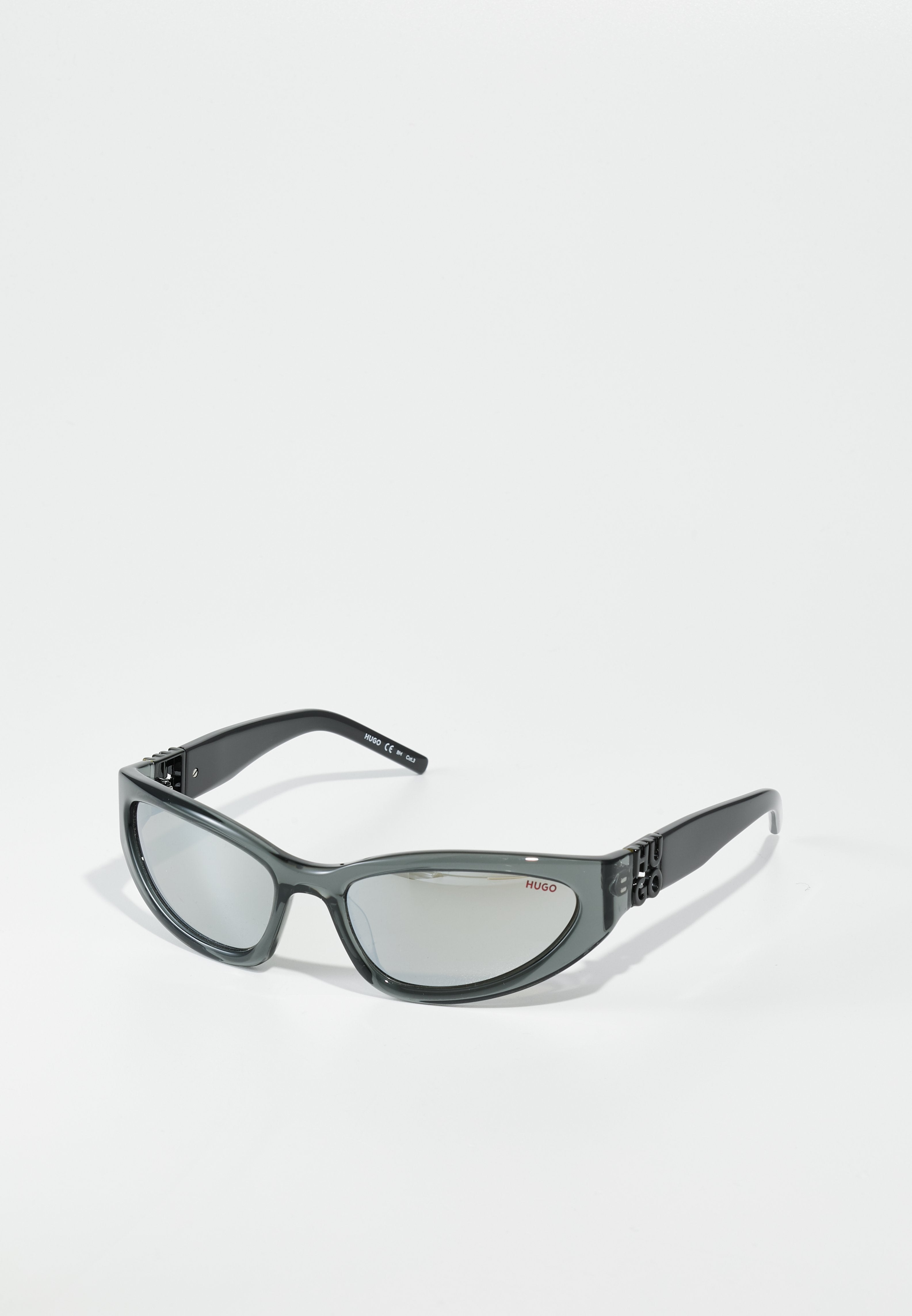 Graue Kunststoffsonnenbrille mit verspiegelten Gläsern, leicht gebogener Form und Logo-Elementen an den Schläfen. Verfügt über ein schlankes, modernes Design.