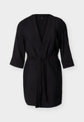 Schwarzes Wickelkleid knielang mit dreiviertel Ärmeln und einem Taillengürtel, präsentiert vor hellem Hintergrund.