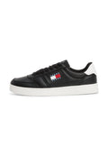 Schwarze Leder-Sneaker mit weißer Sohle, Schnürung vorne und einem Logo-Patch mit roten, weißen und blauen Streifen an der Seite.