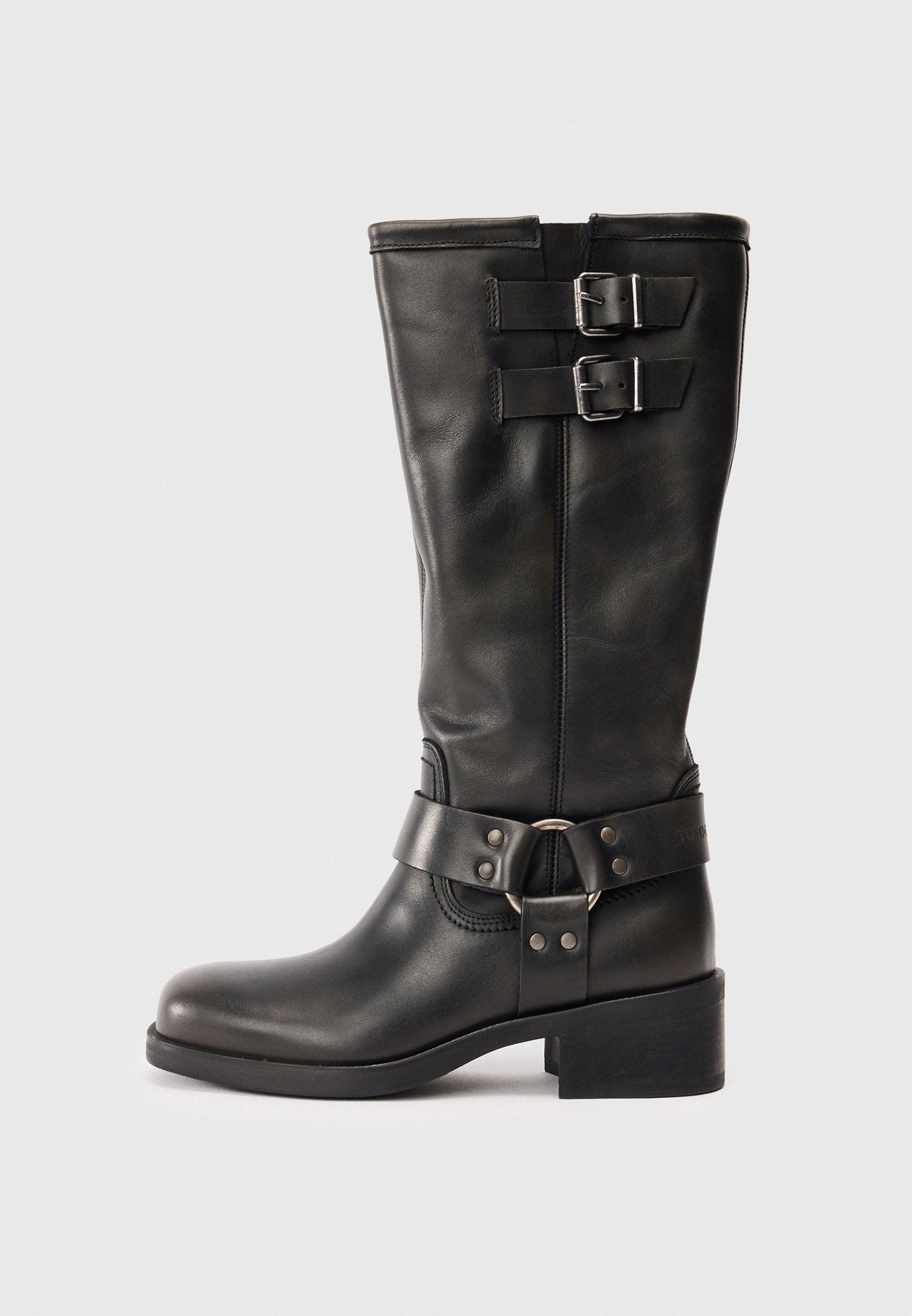 Schwarze Lederstiefel bis zur Mitte der Wade mit zwei silbernen Schnallen oben und einem dekorativen Riemen mit einem Metallring um den Knöchel, Blockabsatz.