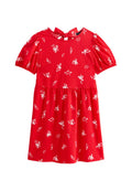 Rotes Kleid mit kurzen Puffärmeln, Blumenmuster in Weiß, figurbetonter Oberkörper mit gerafftem Taillenbereich und einer Bindeschließe im Rückenbereich des Ausschnitts.