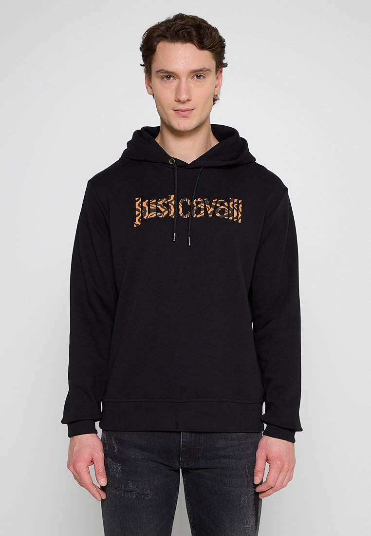 Schwarzer Hoodie aus weichem Material mit Kapuze und Kordelzug. Mit einem orangefarbenen, gemusterten Grafiktext "just cavalli" auf der Vorderseite.