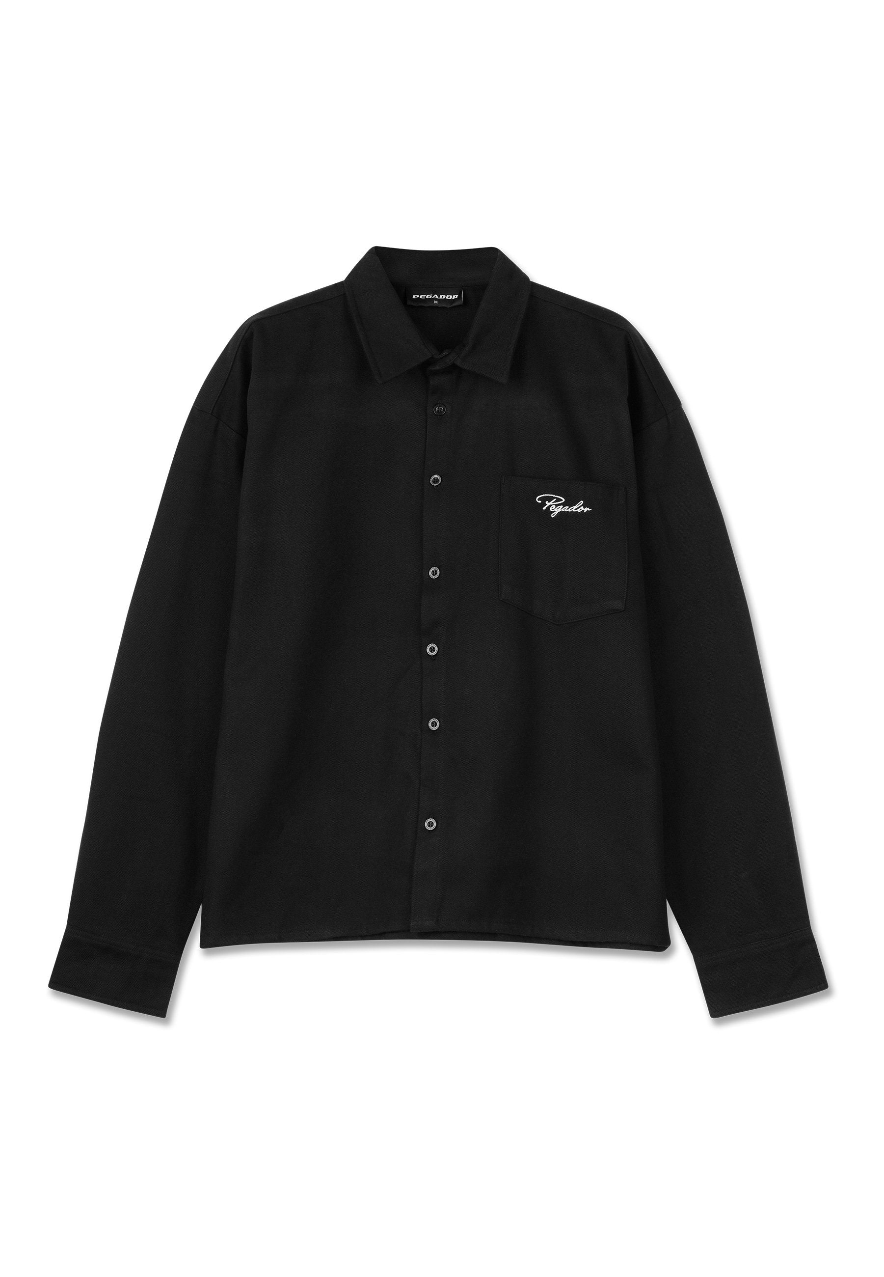 Schwarzes Langarmshirt aus Stoff, mit Kragen, Knopfleiste, einer Brusttasche und aufgesticktem Logo in Weiß auf der Tasche.