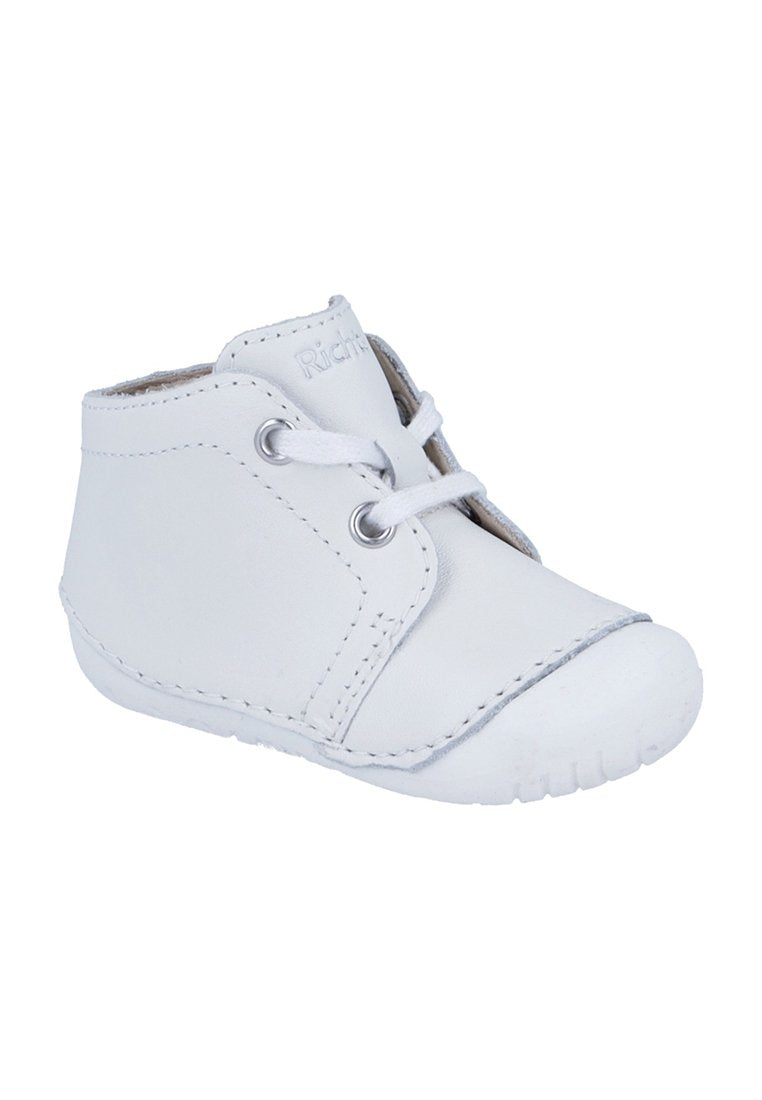 Weißer Babyschuh aus Leder mit Schnürsenkeln, weicher Sohle und verstärkter Zehenpartie, entworfen für frühe Laufanfänger.