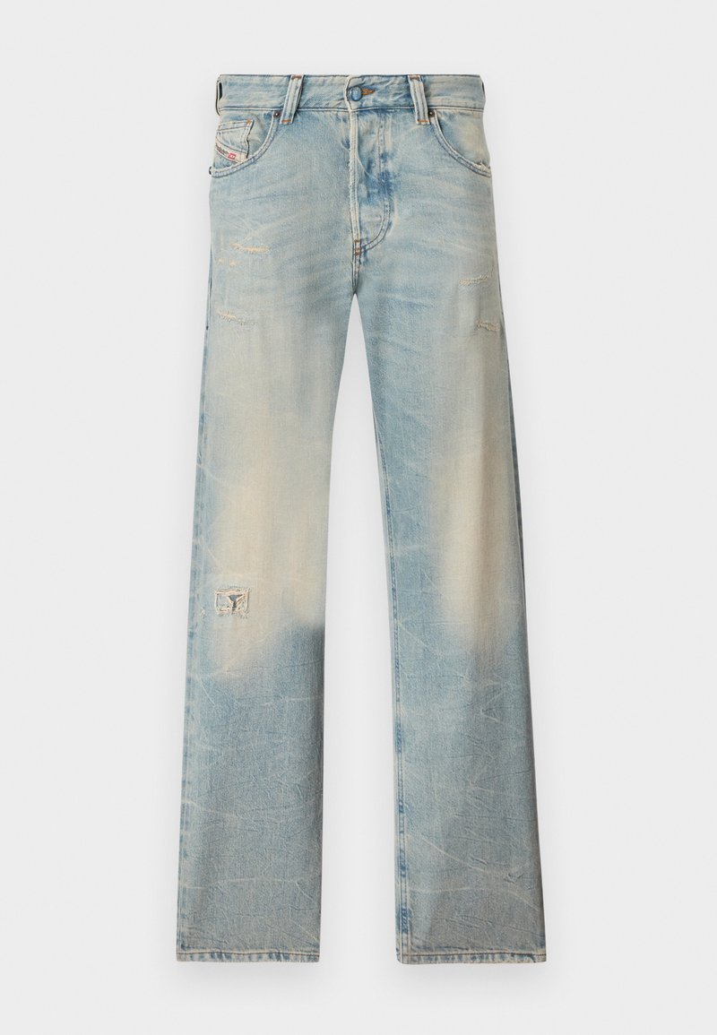 Hellblaue Denim-Jeans mit geraden Beinen, verblassten und abgenutzten Details, einschließlich kleiner Risse an den Oberschenkeln und einem Flicken am linken Bein.