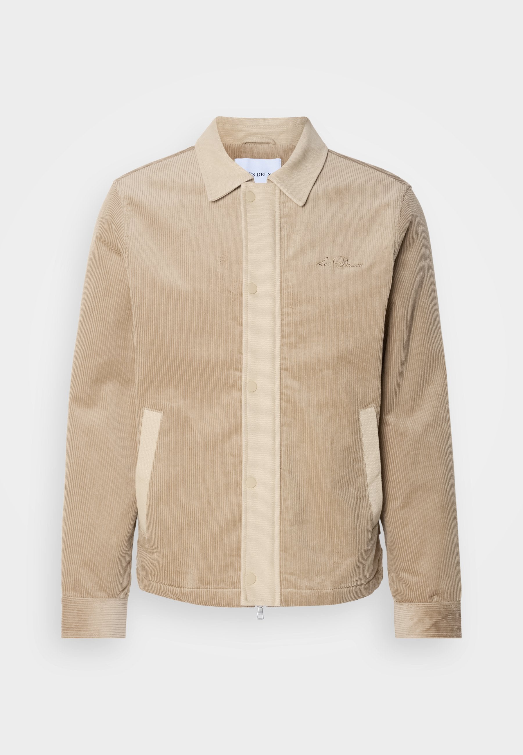 Beige Cordjacke aus Cord mit tanfarbenen Details an der Front, dem Kragen und den Taschen. Verfügt über eine Knopfverschluss und gerippte Bündchen. Subtile Markenkennzeichnung auf der Brust.