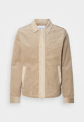 Beige Cordjacke aus Cord mit tanfarbenen Details an der Front, dem Kragen und den Taschen. Verfügt über eine Knopfverschluss und gerippte Bündchen. Subtile Markenkennzeichnung auf der Brust.