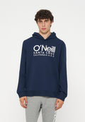 Junger Mann mit lockigem Haar, der einen dunkelblauen O'Neill Hoodie und graue Jogginghosen trägt, steht vor einem schlichten weißen Hintergrund.