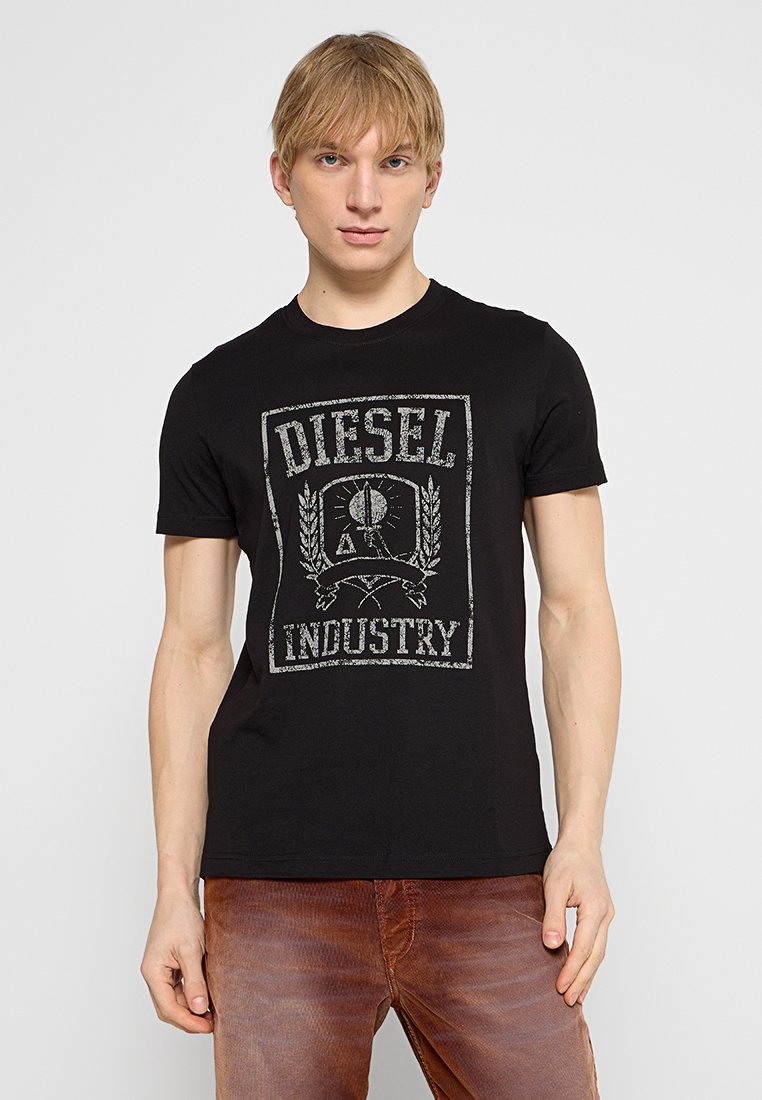 Schwarzes Baumwoll-T-Shirt mit einem verwaschenen grauen Grafikdruck, auf dem "DIESEL INDUSTRY" steht. Kurze Ärmel, runder Ausschnitt, taillierte Passform.