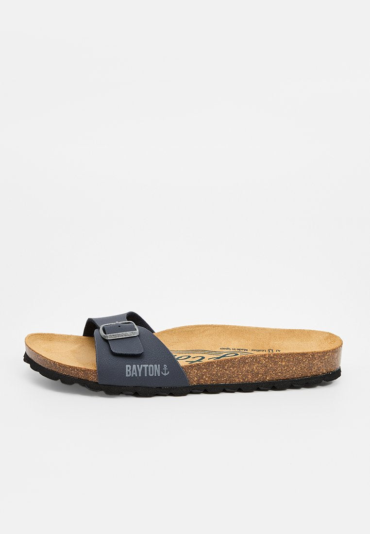 Ein einzelner navy-blauer Rutschsandal mit verstellbarem Schnallenriemen, Korkfußbett und schwarzer Textursohle, mit der Markierung "BAYTON" auf dem Riemen.