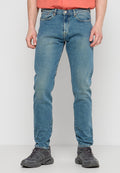 Hellblaue Jeans im fitted Design, klassischer Five-Pocket-Stil und leichter Ausbleichung. Kombiniert mit dunkelgrauen Sportschuhen.