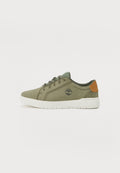 Olivgrüne Wildleder-Sneakers mit einer weißen Gummisohle, Schnürdesign und einem braunen Lederakzent an der Ferse mit einem Logo.