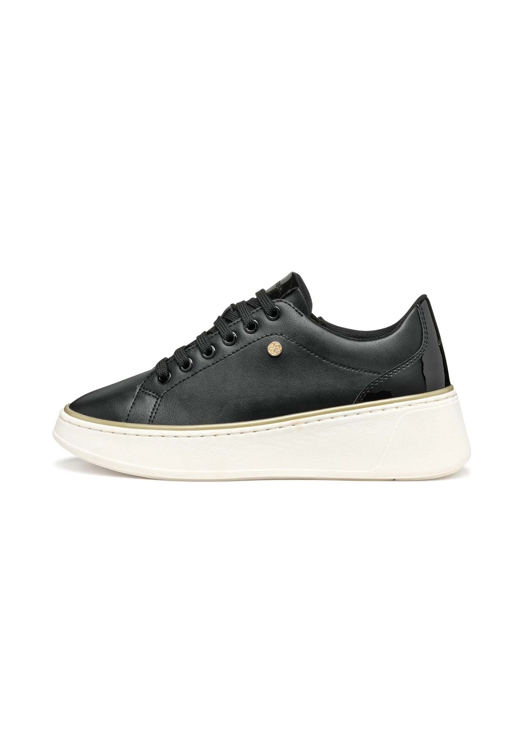 Schwarzer Sneaker aus Leder in niedriger Ausführung mit schwarzen Schnürsenkeln, goldfarbenem Knopfdetail und dicker weißer Plateausohle vor weißem Hintergrund.