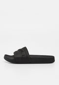 Schwarze Slip-On-Slide-Sandale mit strukturierter Sohle und erhabenem Markennamen auf dem breiten Riemen und an der Seite des Fußbetts.