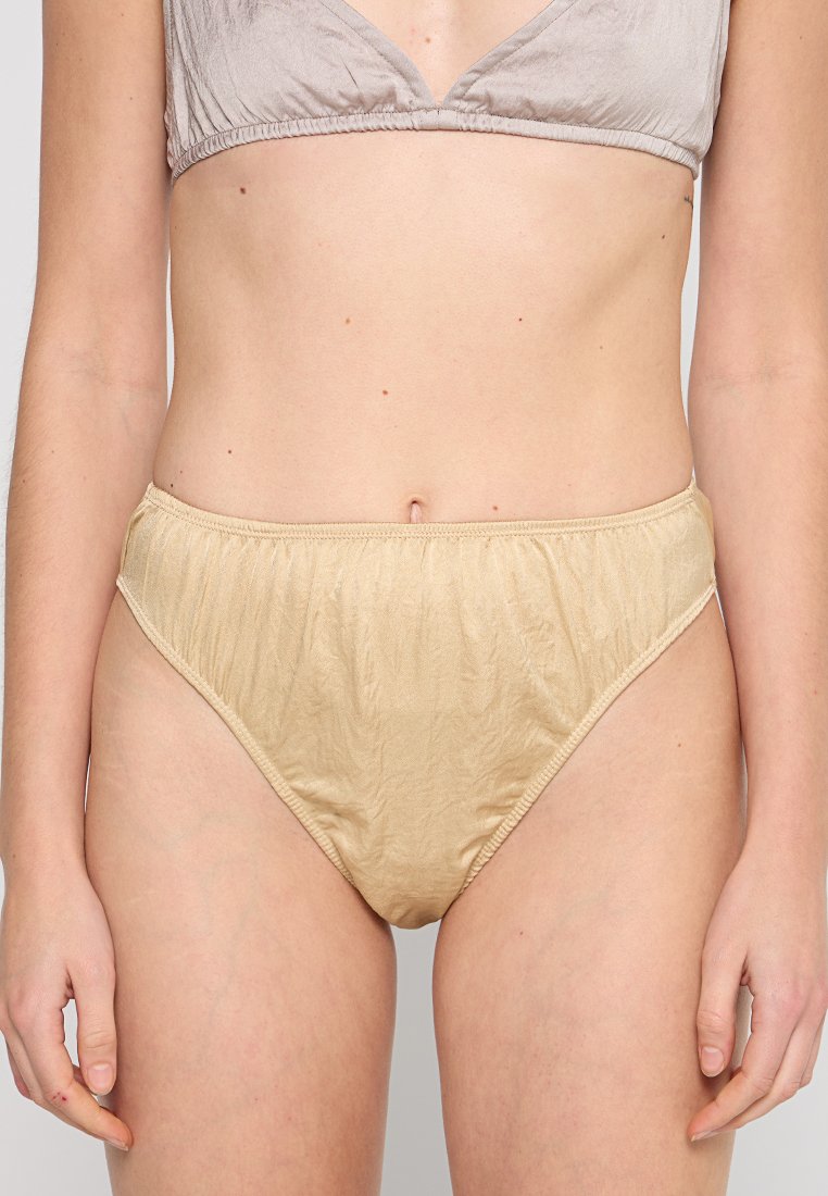 Beige, hochtaillierte Unterwäsche aus weichem, leicht gerafftem Stoff, mit gerafften Nähten und einem elastischen Bund für zusätzlichen Komfort.