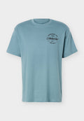 Hellblaues Nike T-Shirt mit kurzen Ärmeln und rundem Halsausschnitt mit schwarzem Text "Established 1972 Nike Athletic Club Just Do It" auf der linken Brust.