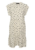 Kleid mit floralem Druck in Creme, mit kurzen Ärmeln, rundem Halsausschnitt und gestuftem Saum. Mit kleinen schwarzen Blumen, die gleichmäßig verteilt sind.