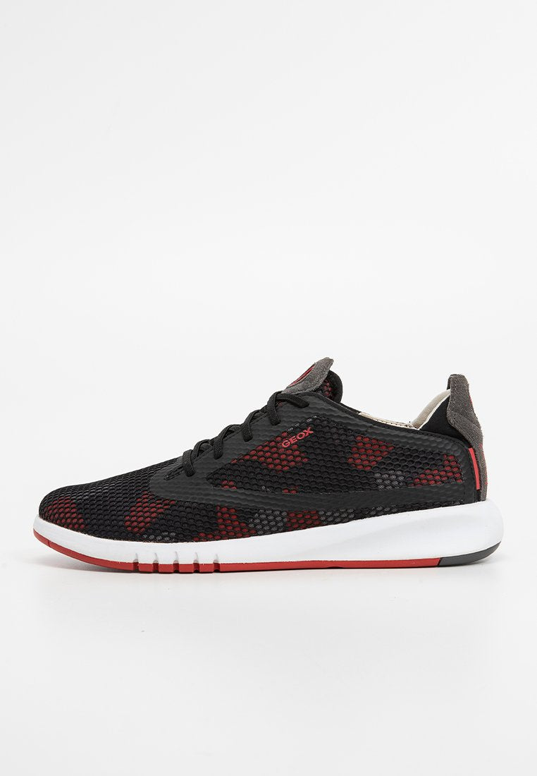 Schwarze und rote Mesh-Sneaker mit einer strukturierten Oberseite, kontrastierenden Details, weißer Schaumsohle und einem Logo an der Seite.