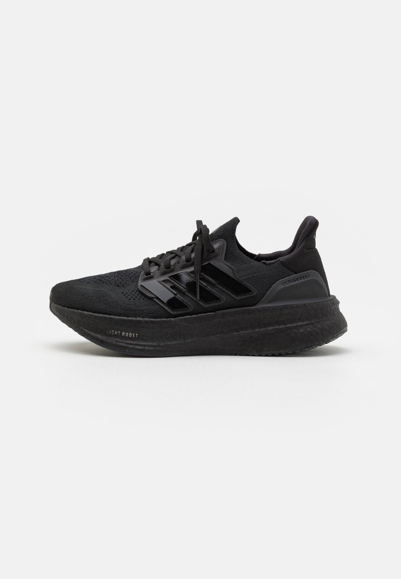 Schwarze Sportschuhe mit einem strukturierten Strick-Obermaterial, drei glänzenden Streifen, einer leichten Schaumsohle und verstärktem Absatz. Mit Schnürdesign.
