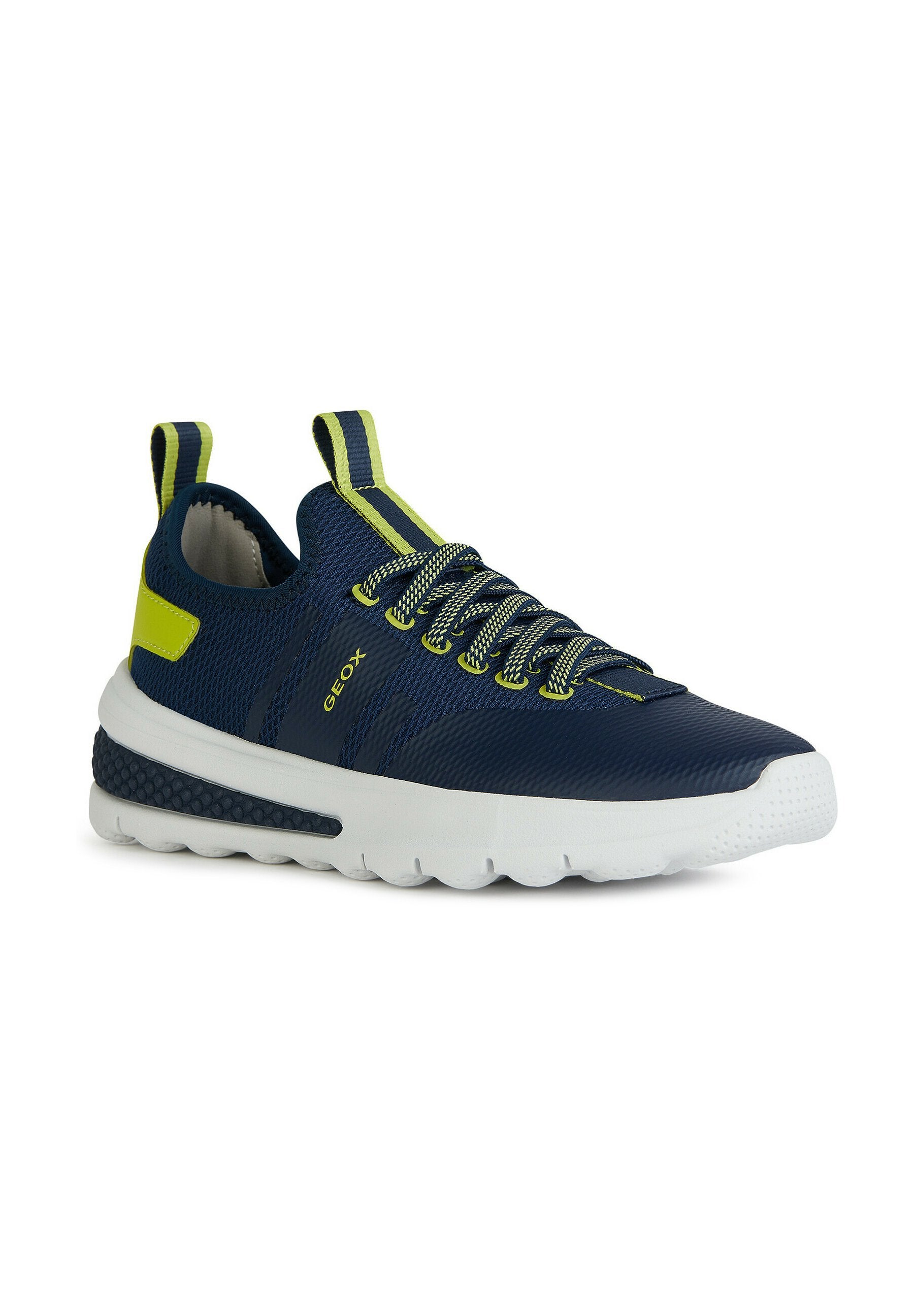Marineblaue Sportschuhe mit weißer Sohle, strukturiertem Mesh-Obermaterial, gelben Akzenten und elastischen Schnürsenkeln; Zuglasche an der Ferse für einfaches An- und Ausziehen.
