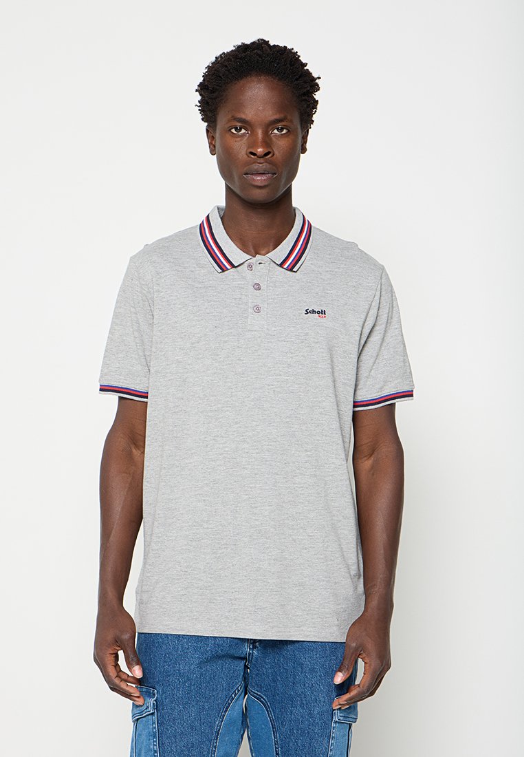 Mann trägt ein hellgraues Poloshirt mit rot-weiß-blau gestreiftem Kragen und Ärmelsäumen, kombiniert mit blauen Cargo-Jeans.